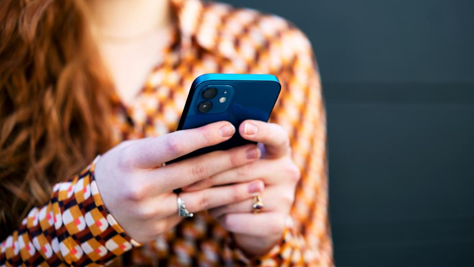 A woman uses a mobile phone