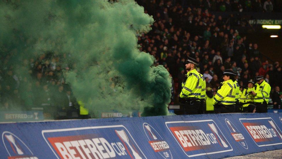 flare with green smoke is thrown pitchside during the Betfred Cup Final between Celtic and Aberdeen at Hampden Park on December 2, 2018