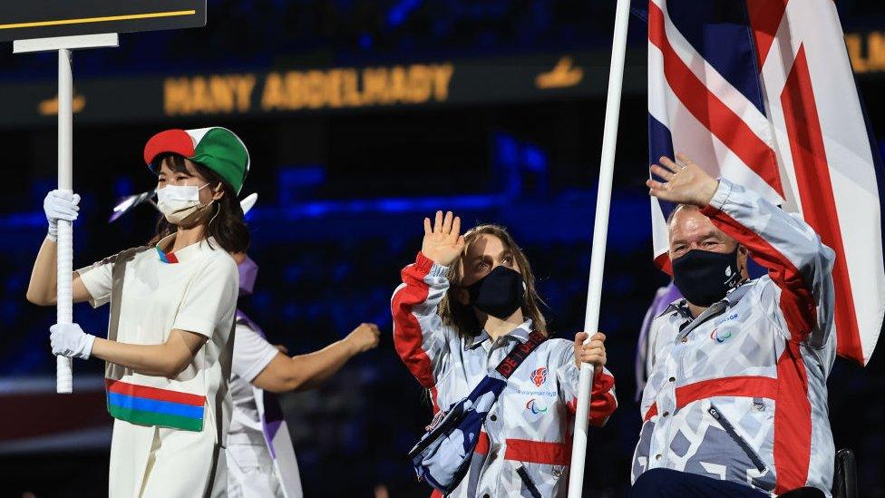 ellie-simmonds-and-john-stubbs-holding-union-jack-wave-at-stadium