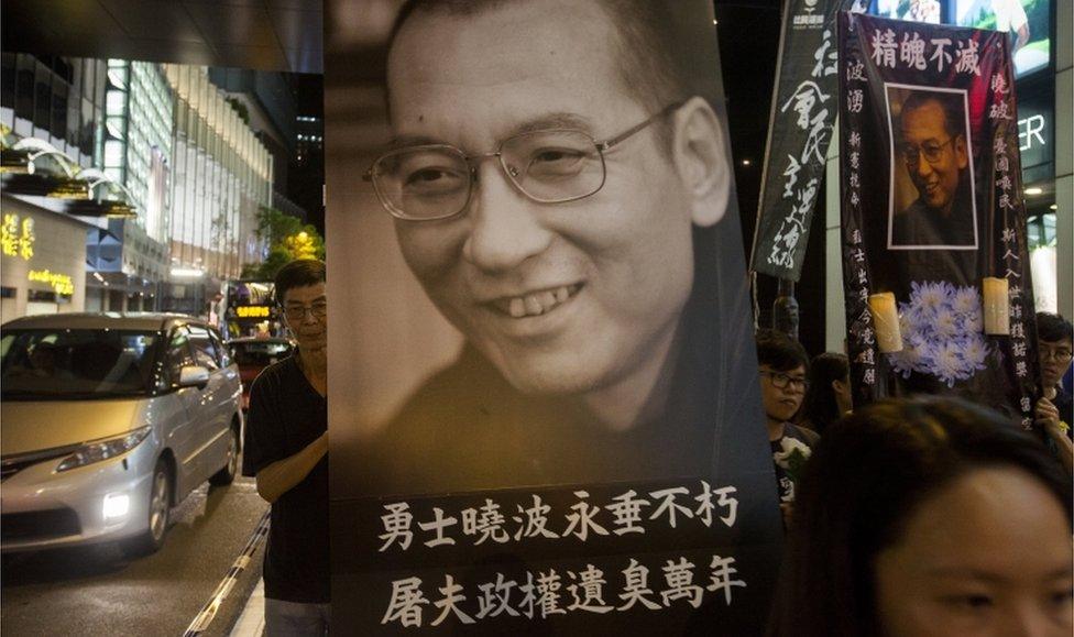 Members of the League of Social Democrats hold a large portrait of Liu Xiaobo, as they march through the streets of Hong Kong to demand the release of Liu Xia, his widow, on 15 July 2017.