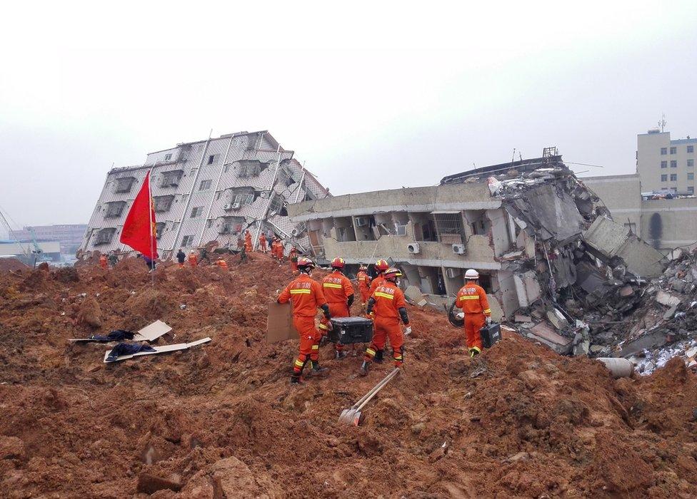 Firefighters search for survivors among the rubble of collapsed buildings after a landslide hit an industrial park in Shenzhen, Guangdong province, China, 21 December 2015.