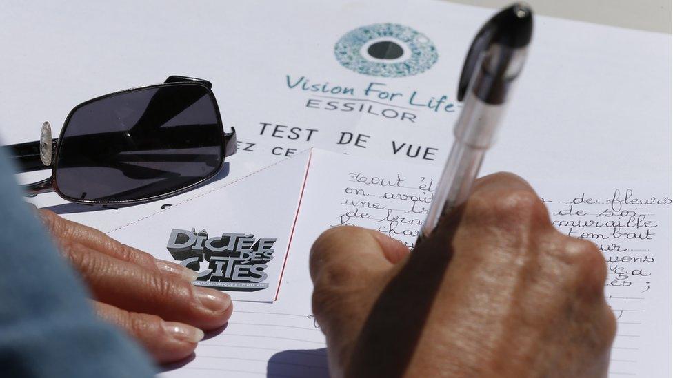 A person takes part in the 'Dictee des cites' an open-air free dictation exercise for adults and children in Saint-Denis, near Paris (May 2015)