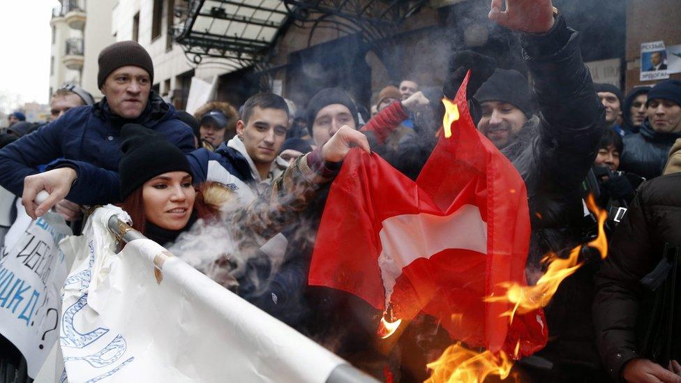 Russians burn a Turkish flag during a rally in front of Turkish embassy in Moscow