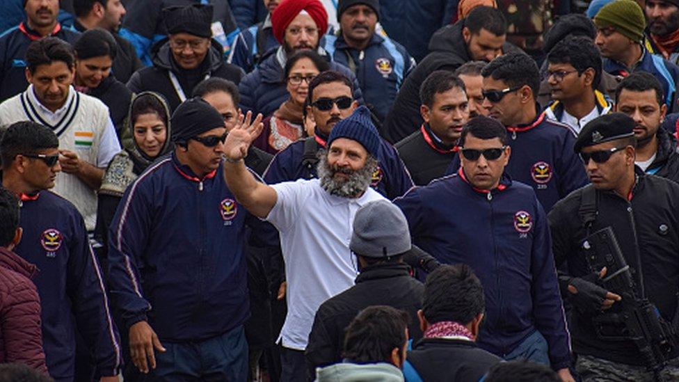 Rahul Gandhi (in white C) waves at supporters and former chief minister of Jammu and Kashmir Mehbooba Mufti (R) during the Bharat Jodo Yatra in Anantnag, South Kashmir