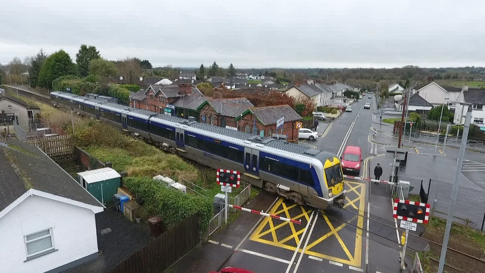 A train moves along a level crossing track in Cullybackey