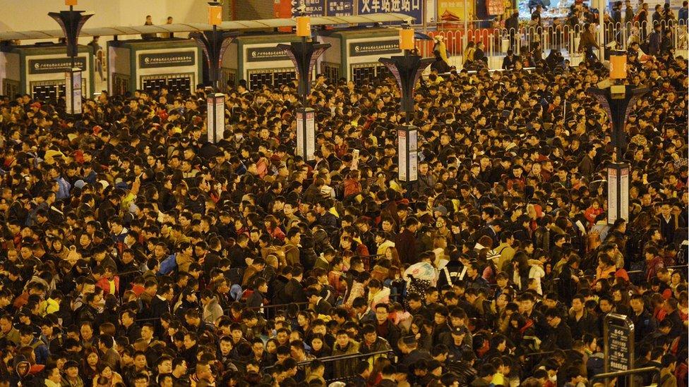 Passengers wait to enter a railway station in Guangzhou