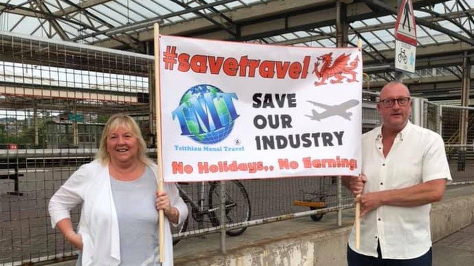 Ann Jones and her employee holding a banner