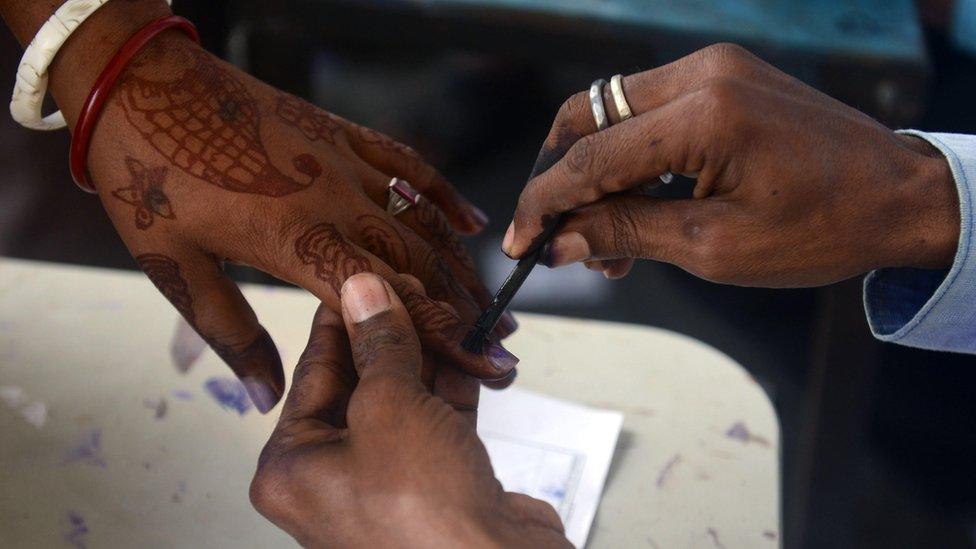 Election official applies ink to female voter's hand, Bihar (5 November)