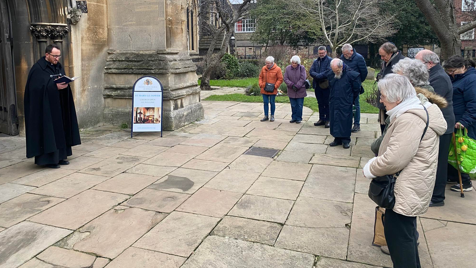 Prayers being said outside St Mary le Tower Church in Ipswich in memory of Mr Quigley