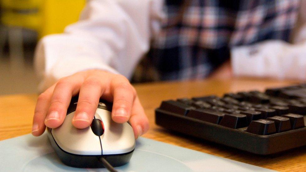 Young person's hand on computer mouse