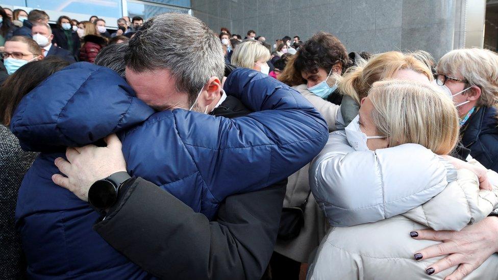 People embrace after holding a minute's silence for David Sassoli