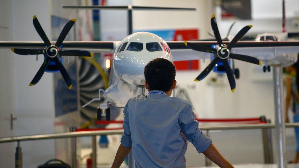 A man looks at an aircraft scale model at the Aviation Industry Corporation of China booth during an expo in Beijing in 2015