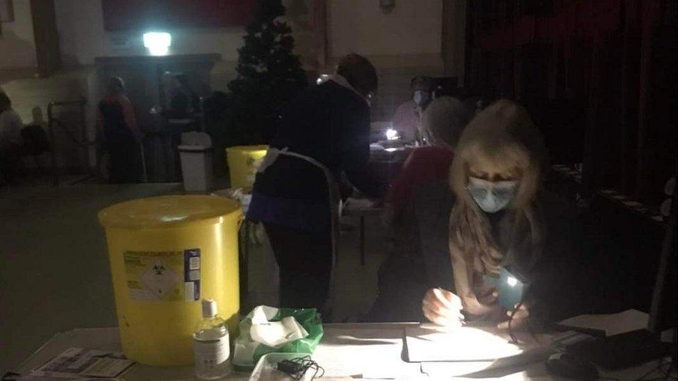 Jab volunteers working by torch light