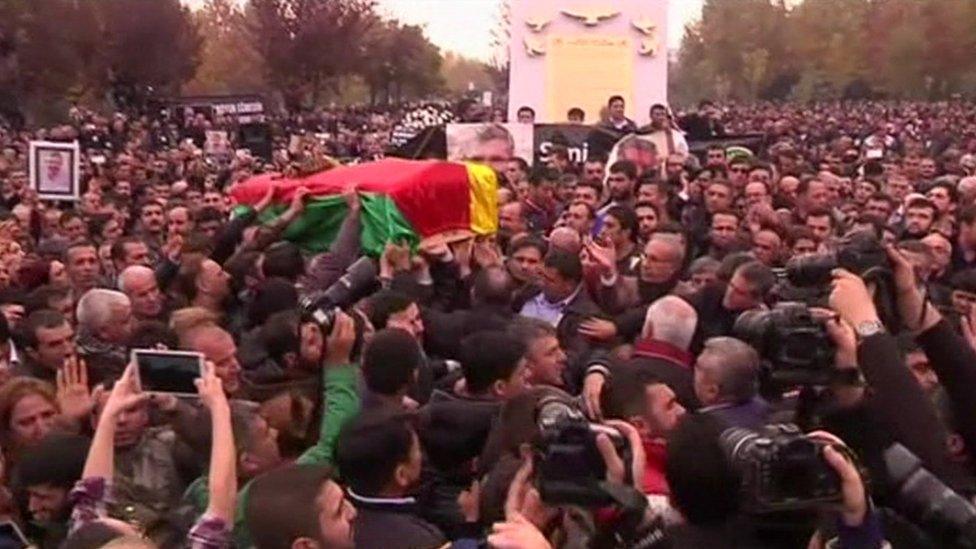 Mr Elci's coffin is carried through massive crowds, draped in the red, yellow and green Kurdish flag