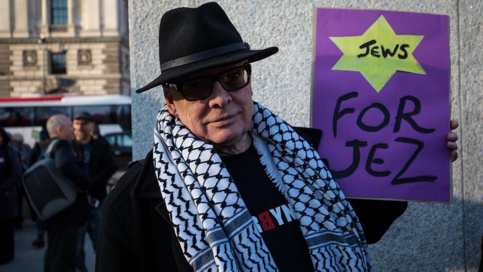 A man with a sign saying "Jews for Jez"