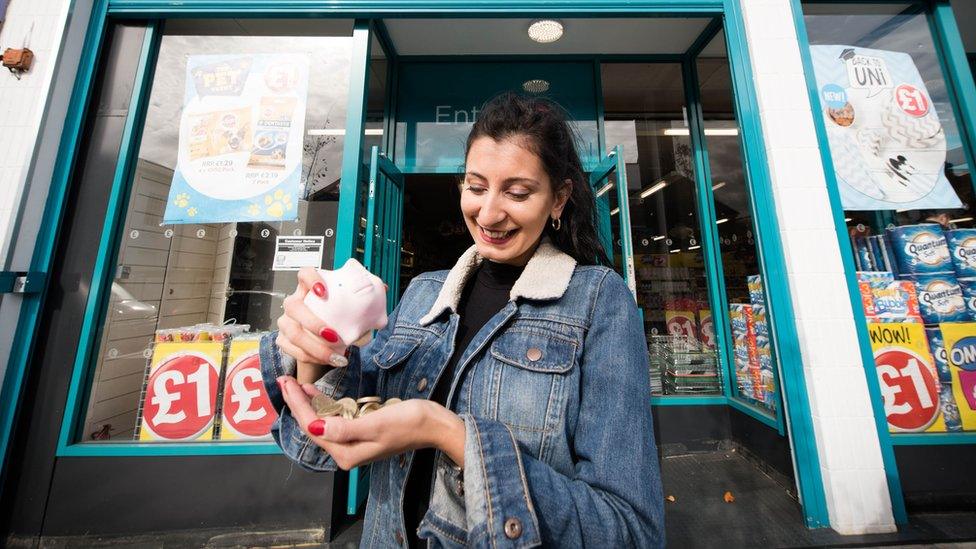 A woman with pound coins outside a Poundland shop