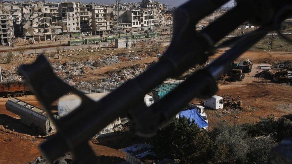 An armed member of the Syrian pro-government forces watches buses during the evacuation from eastern Aleppo. Photo: 15 December 2016