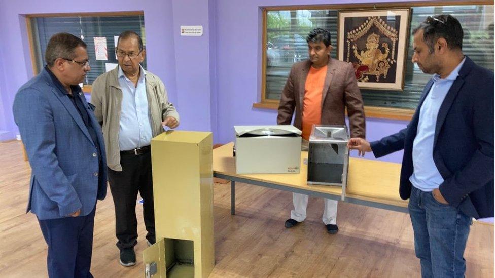 Swindon Hindu Temple trustees looking at the cash boxes which were broken into