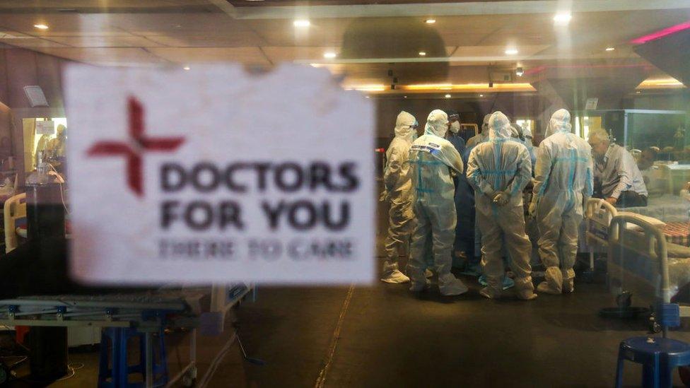 Doctors and healthcare staff wearing Personal Protective Equipment suits (PPE) attend to Covid-19 patient inside a Covid-19 care center in Delhi.