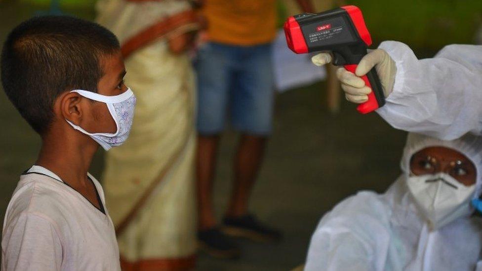 Medical staff take the temperature of a child at a COVID-19 coronavirus community clinic