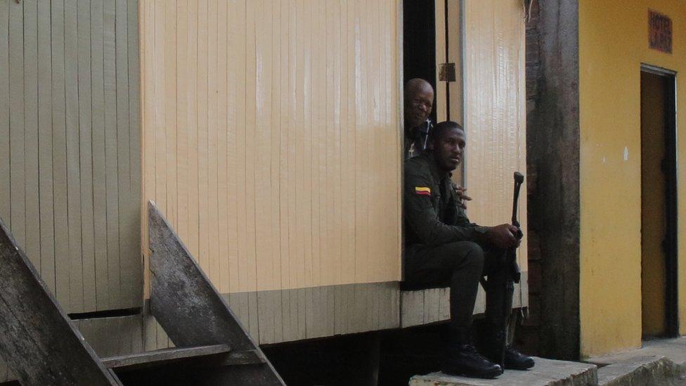 Police officers sit on the steps of a house