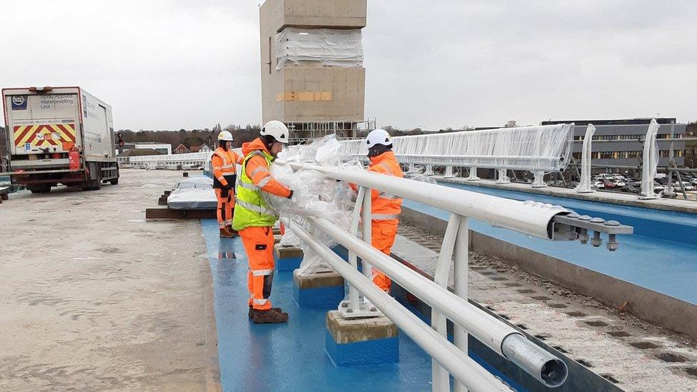 Workers in high visibility jackets working on part of the bridge.