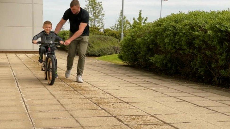 Noah on bike with dad