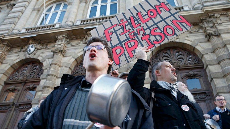 Demonstrators protest with pots and a placard that reads "Fillon in prison" - 17 February 2017