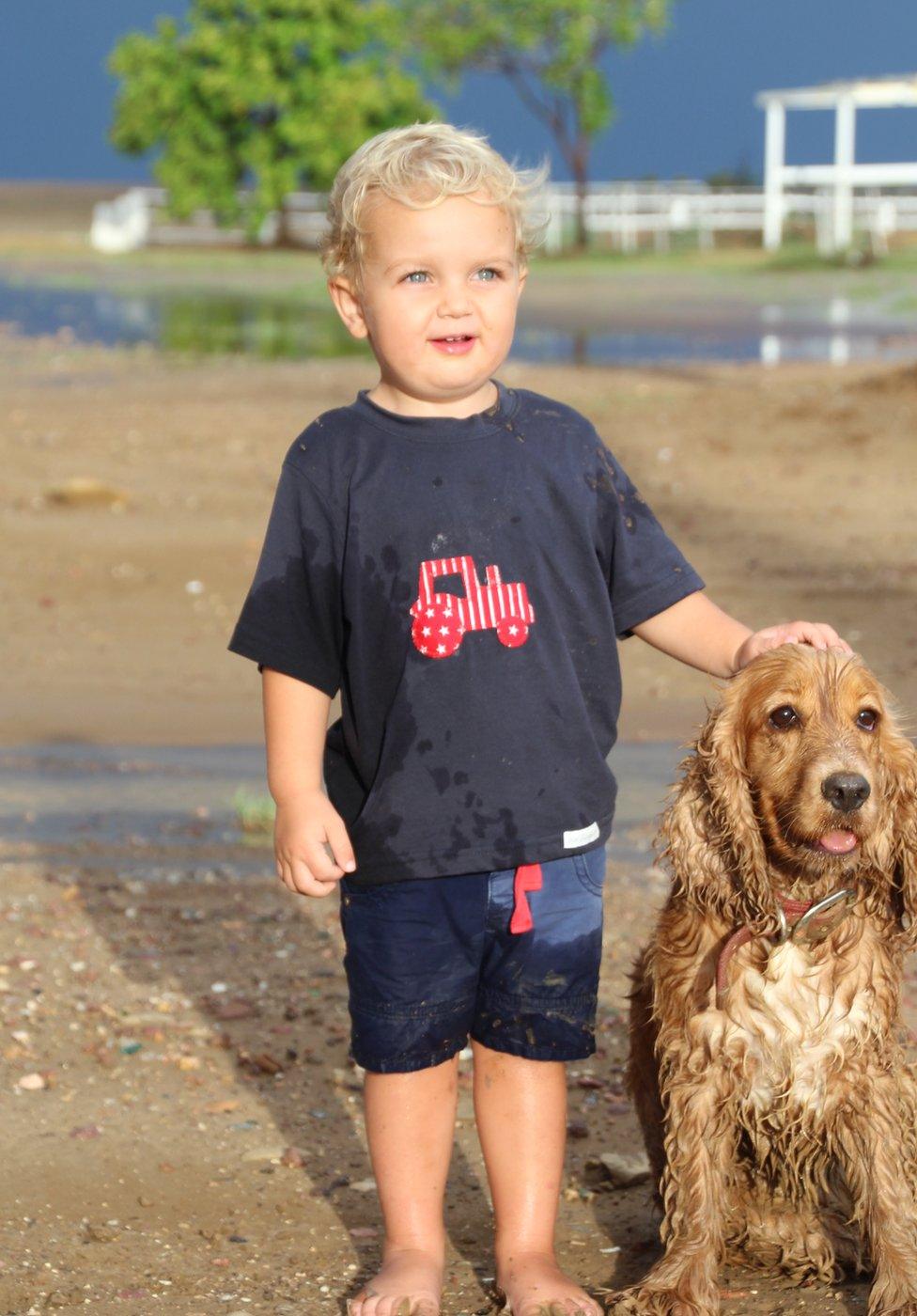 James Walker (junior) watching his first rain fall with the family dog