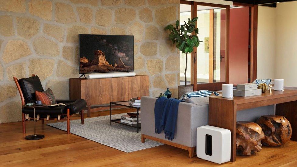 The Sonos soundbar is seen in a very expensively furnished stage home, complete with matching subwoofer and rear speakers