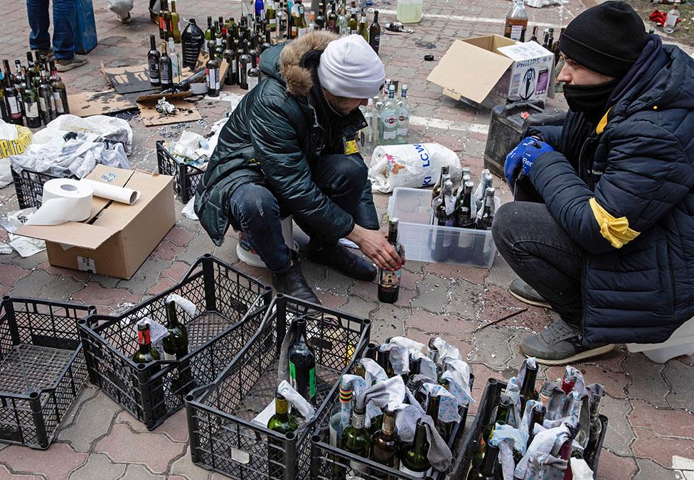 Members of the Territorial Defence Forces of Ukraine prepare Molotov cocktails in Kyiv on 27 February 2022