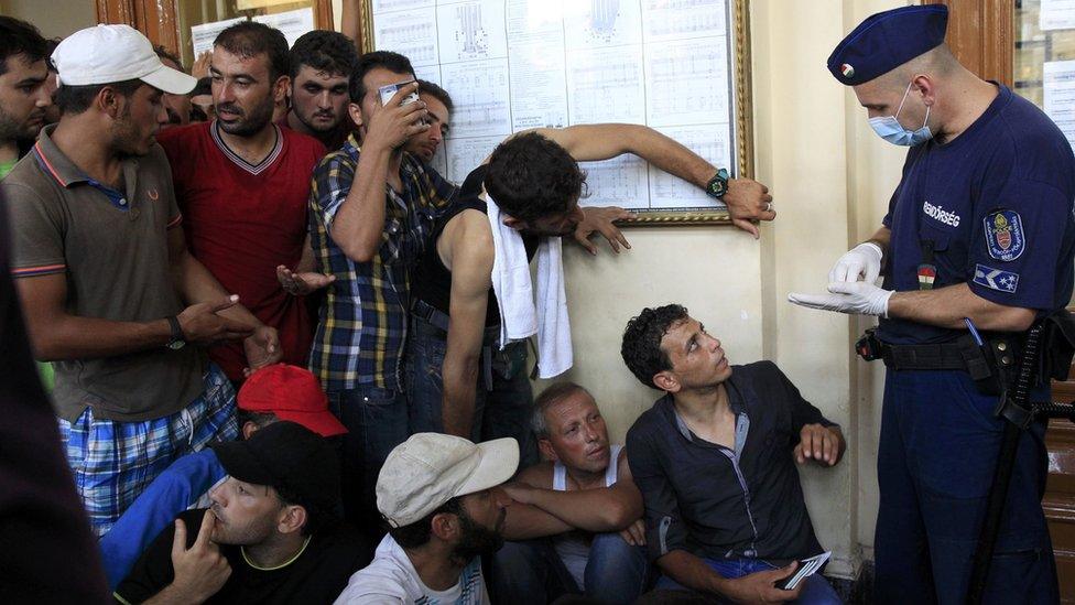 Police speaking to migrants at a Budapest train station, 31 Aug 15