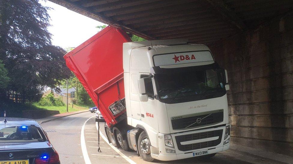 A lorry stuck under a bridge