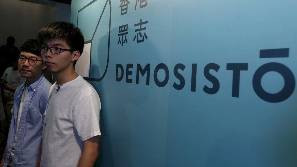 Student leader Joshua Wong (R) and Chairman Nathan Law pose in front of a backdrop during the launch ceremony of their new political party Demosisto in Hong Kong, 10 April 2016