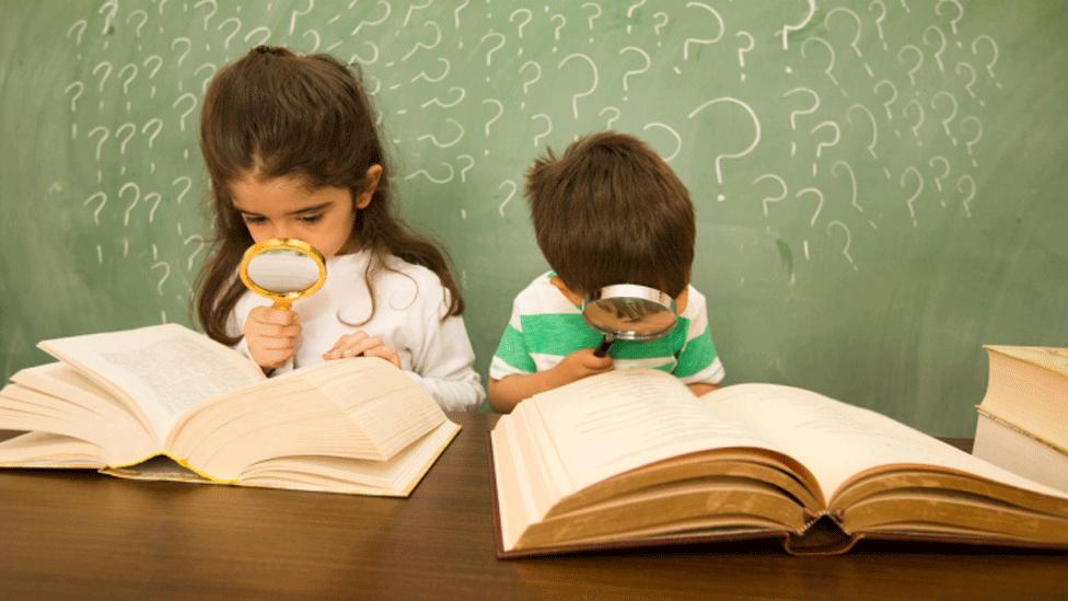 Children looking for clues with magnifying glass