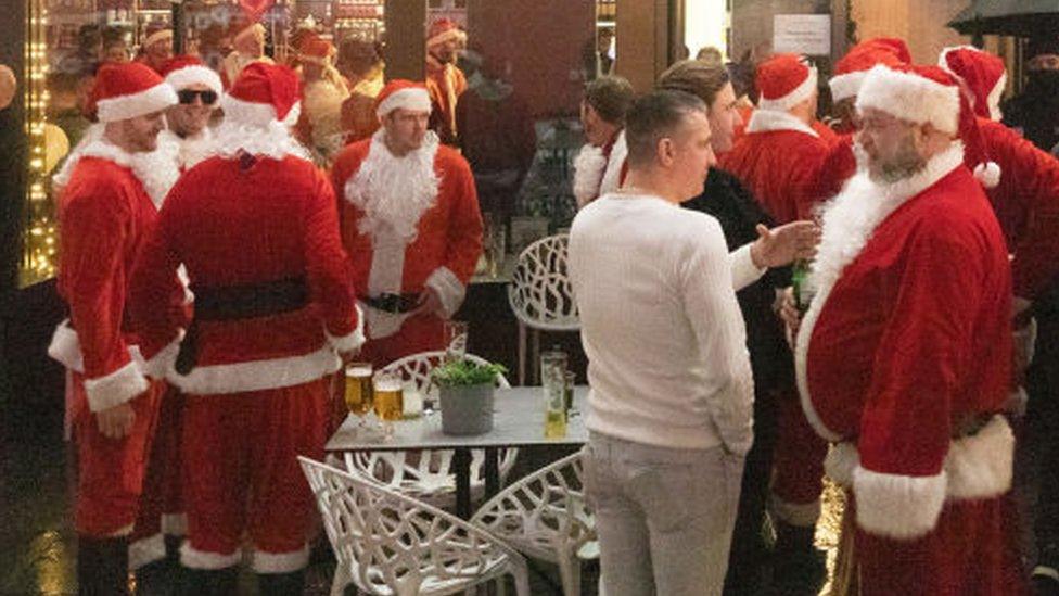 Father Christmases outside a bar