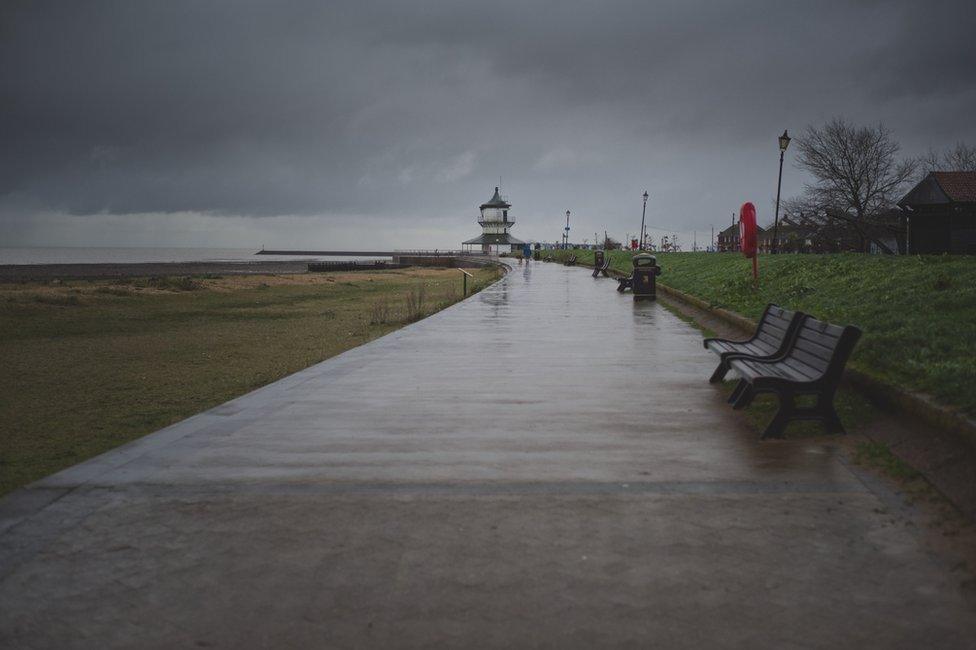 A lone dog walker makes his way towards the Harwich Low Lighthouse