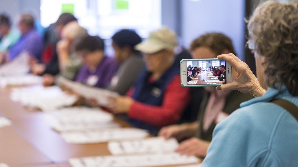 Shelia Banks Parks, of Massachusetts and a Jill Stein designated observer, video tapes presidential ballots being recounted in Dane County (Wis.) on December 1, 2016 in Madison