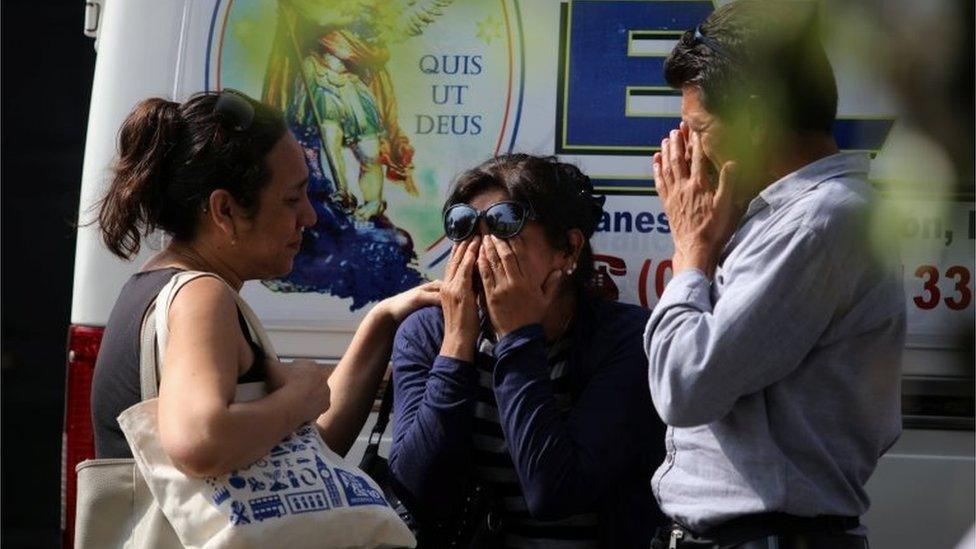 Relatives of the victims of a bus that crashed with a truck and careened off a cliff along a sharply curving highway north of Lima, wait outside a hospital morgue in Chancay, Peru, January 3, 2018.