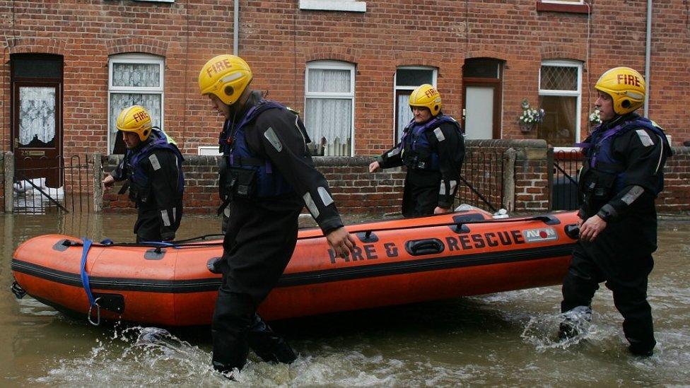 Firefighters search homes in the flooded village of Treeton, near Rotherham