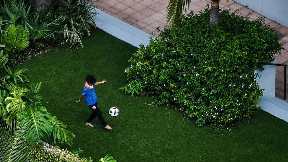 Child playing football in garden