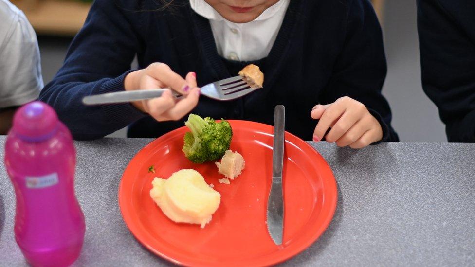 A school girl eating school dinner.