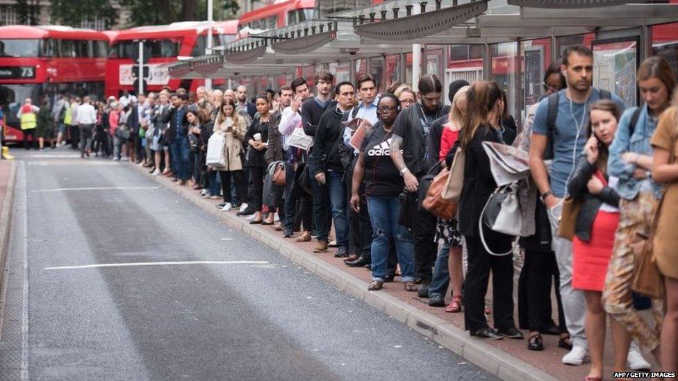 Commuters queue for buses as a 24 hour tube strike hits the morning rush hour at Victoria station, central London