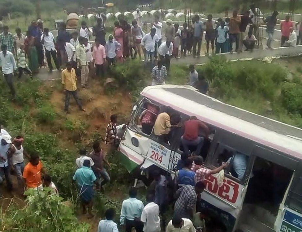 Onlookers and rescuers gather around the bus in Telangana state.