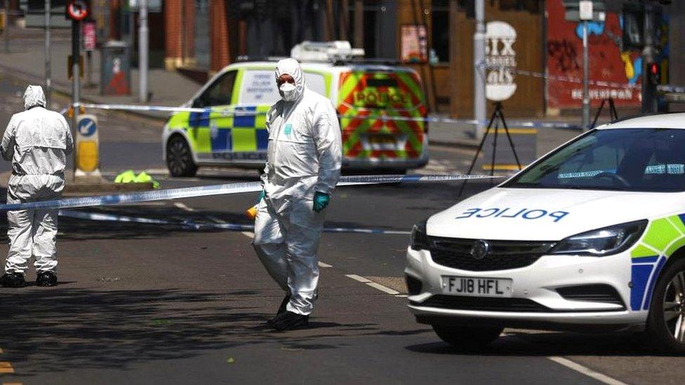 Police forensics officers work at a site cordoned with police tape in Nottingham city centre