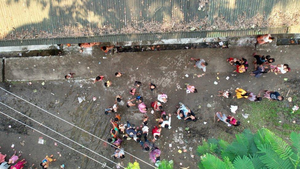 People seen wading through flood waters to arrive at shelter in Silchar city