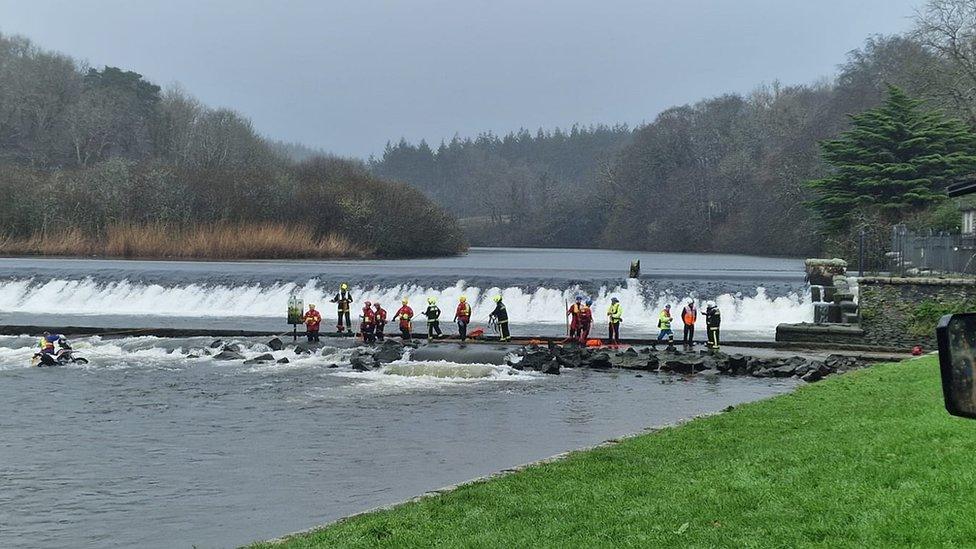 Firefighters and coastguard crew rescuing a motorbike and its rider in Lopwell Dam