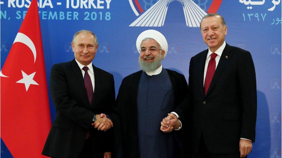 Russian President Vladimir Putin (L), Iranian President Hassan Rouhani (C) and Turkish President Recep Tayyip Erdogan (R) shake hands in Tehran (7 September 2018)