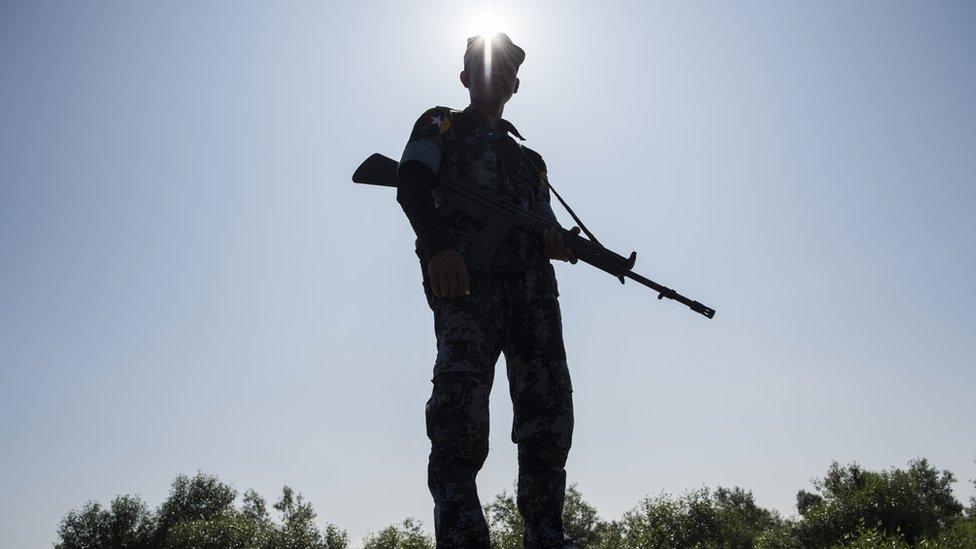 A Myanmar army officer holds a gun near the border with Bangladesh