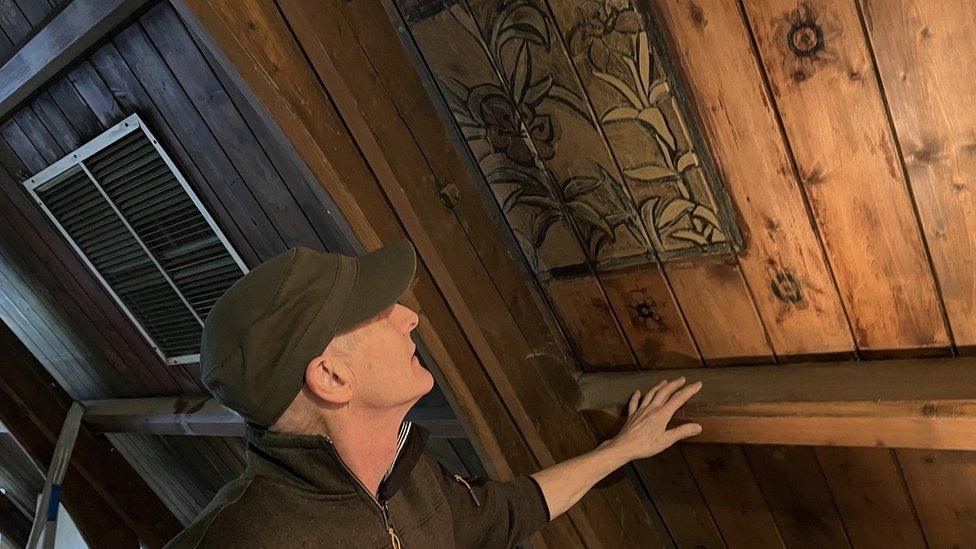 Chris Wemyss inspects one of the floral ceiling panels